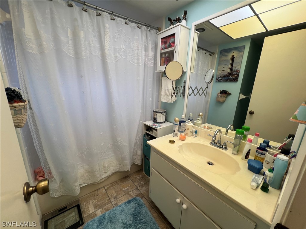 3 Regency Court Lehigh Acres, FL 33936 - Photo 22 of 27 a bathroom with a sink and mirror with bathtub