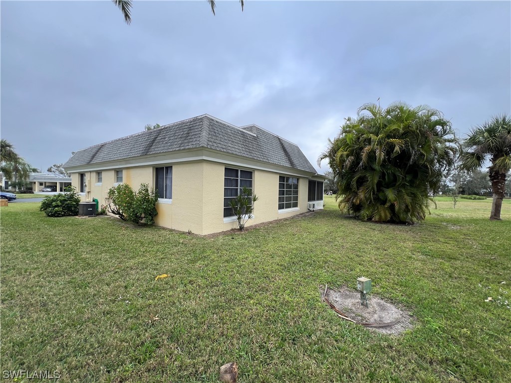 3 Regency Court Lehigh Acres, FL 33936 - Photo 7 of 27 a backyard of a house with table and chairs plants