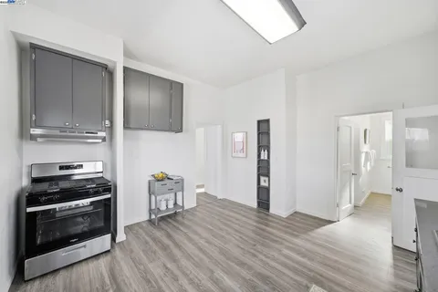 a kitchen with stainless steel appliances a stove and wooden floor