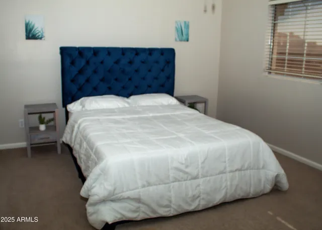 a large bed sitting in a bedroom next to a window