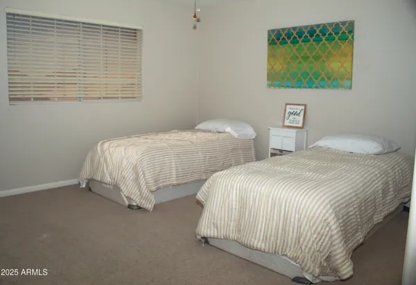 a bedroom with two beds and painting on the wall