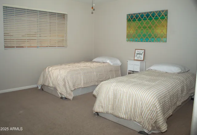 a bedroom with two beds and painting on the wall