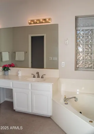 a bathroom with a tub a sink and mirror