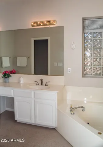 a bathroom with a tub a sink and mirror