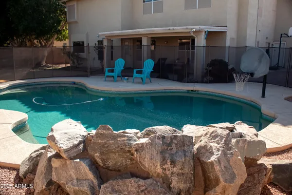 a view of a swimming pool with a patio and a garden