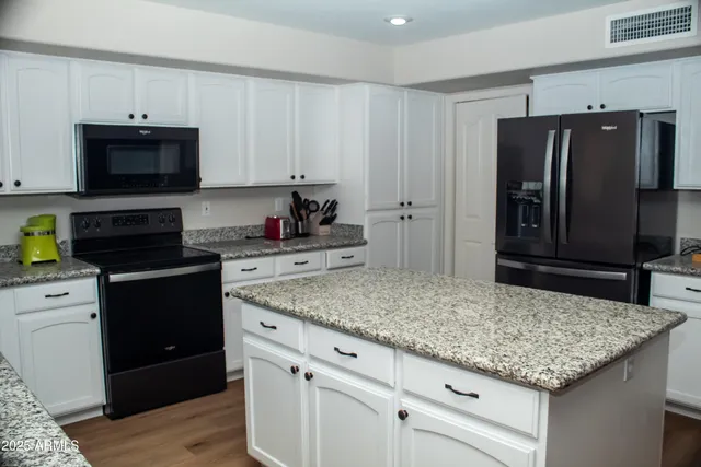 a kitchen with stainless steel appliances granite countertop a refrigerator and a sink