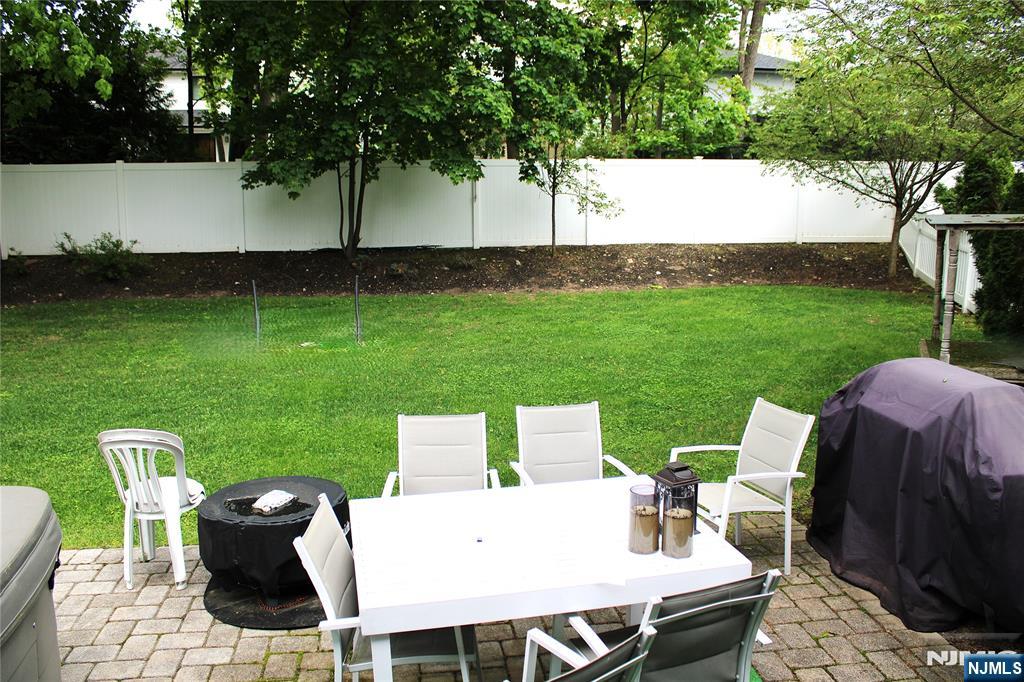 294-296 Tenafly Road Tenafly, NJ 07670 - Photo 22 of 24 a view of a backyard with table and chairs potted plants and large tree