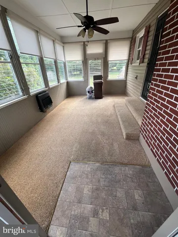 a view of an empty room with a fireplace and a window