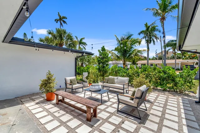 a view of a house with backyard sitting area and furniture
