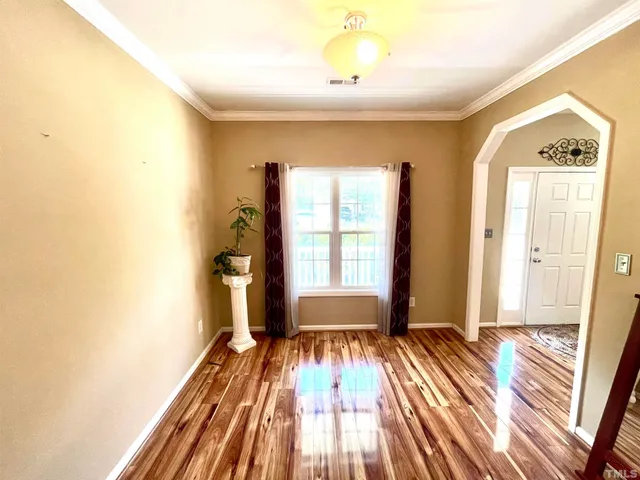 a view of a room with wooden floor and windows