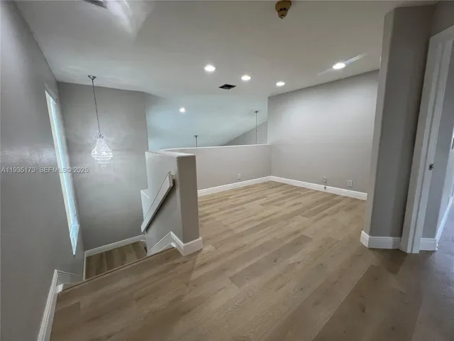 a view of an empty room with wooden floor