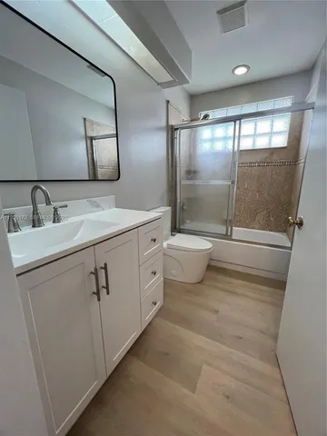 a bathroom with a double vanity sink toilet and mirror