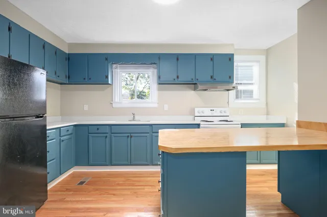 a kitchen with kitchen island granite countertop a sink cabinets and stainless steel appliances