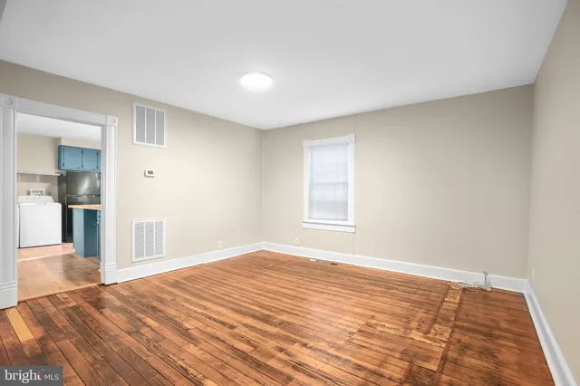 a view of empty room with wooden floor