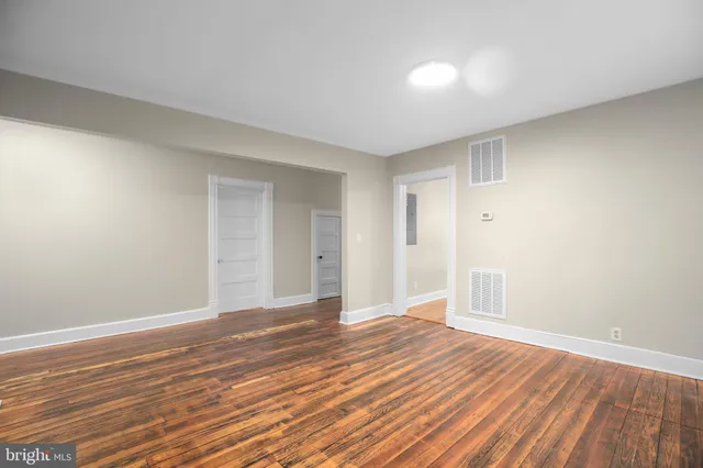 a view of an empty room with wooden floor