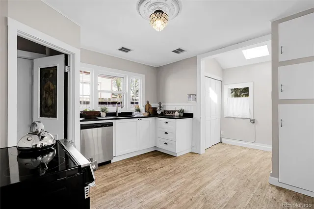 a kitchen with a refrigerator and white cabinets