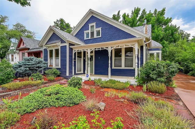 a front view of a house with a yard and potted plants