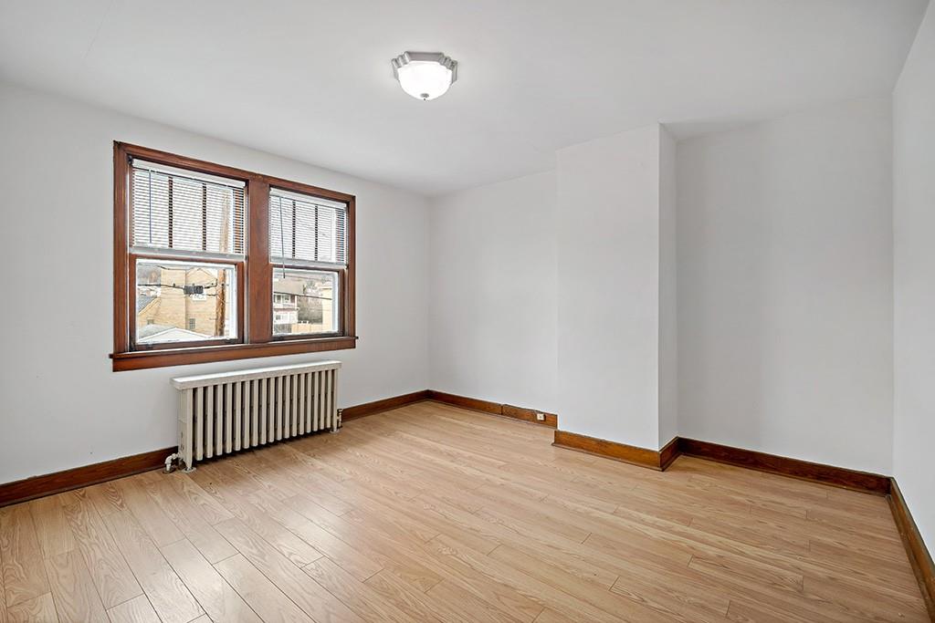1167 Race Street McKees Rocks, PA 15136 - Photo 17 of 25 an empty room with wooden floor and windows