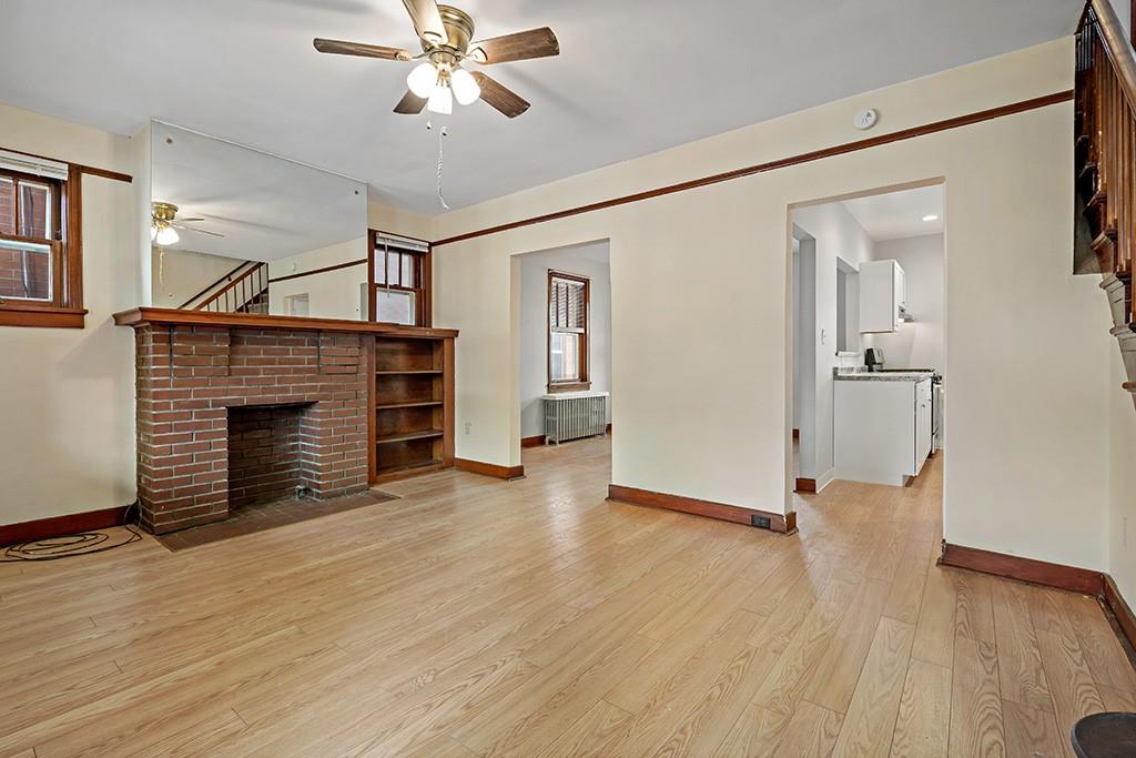 1167 Race Street McKees Rocks, PA 15136 - Photo 4 of 25 a view of a livingroom with wooden floor and a ceiling fan