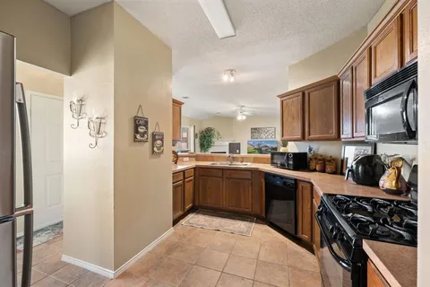 a kitchen with stainless steel appliances granite countertop a refrigerator stove and sink