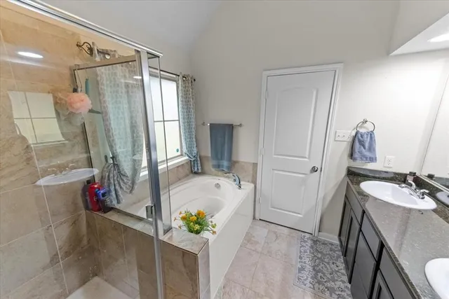 a bathroom with a tub mirror and sink
