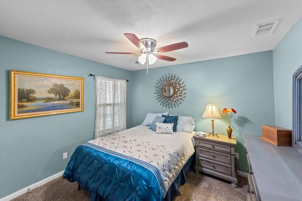 10861 Burnham Drive Waco, TX 76708 - Photo 16 of 27 a bedroom with a bed and a chandelier