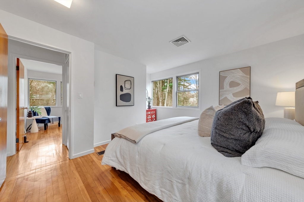 85 The Valley Road Concord, MA 01742 - Photo 21 of 38 a bedroom with a large bed and a wooden floor