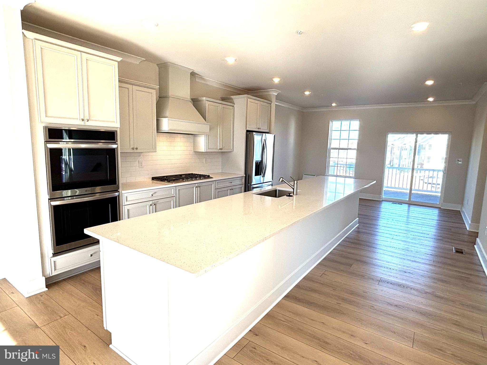 7700 Johnnycake Road Windsor Mill, MD 21244 - Photo 8 of 17 a large kitchen with kitchen island a large counter top space a sink stainless steel appliances and cabinets