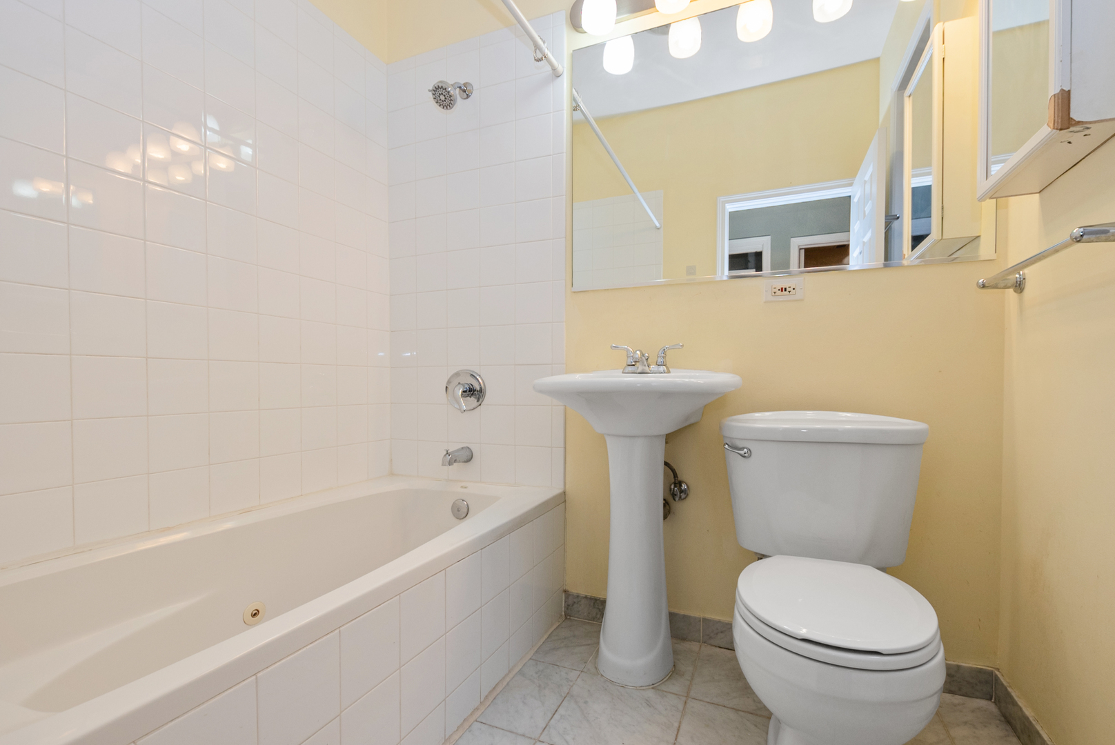 6603 South Kimbark Avenue, Unit 3 Chicago, IL 60637 - Photo 9 of 16 a white toilet sitting next to a white tub