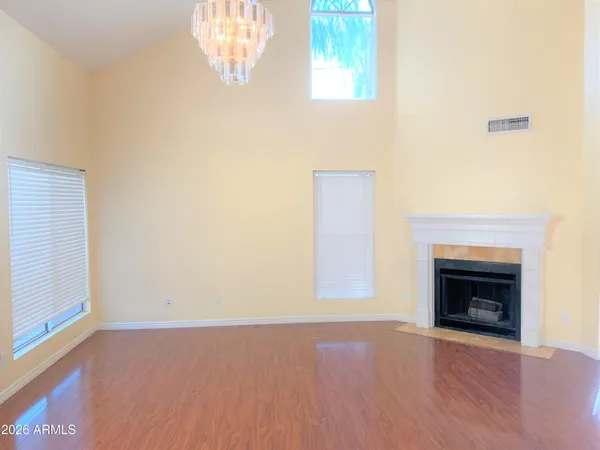 an empty room with windows and fireplace