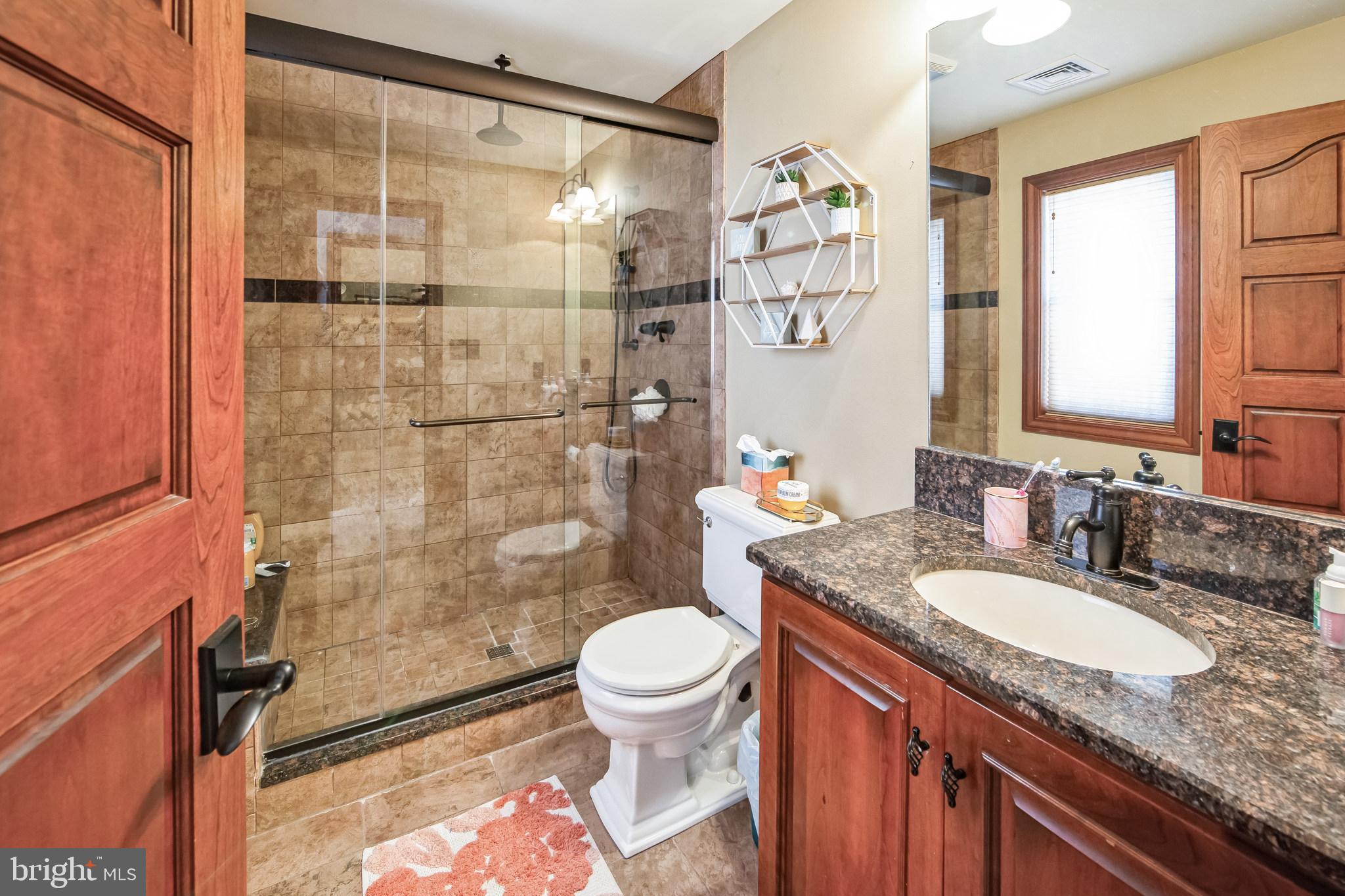 86 Sunset Road Royersford, PA 19468 - Photo 38 of 75 a bathroom with a granite countertop sink toilet a mirror and shower