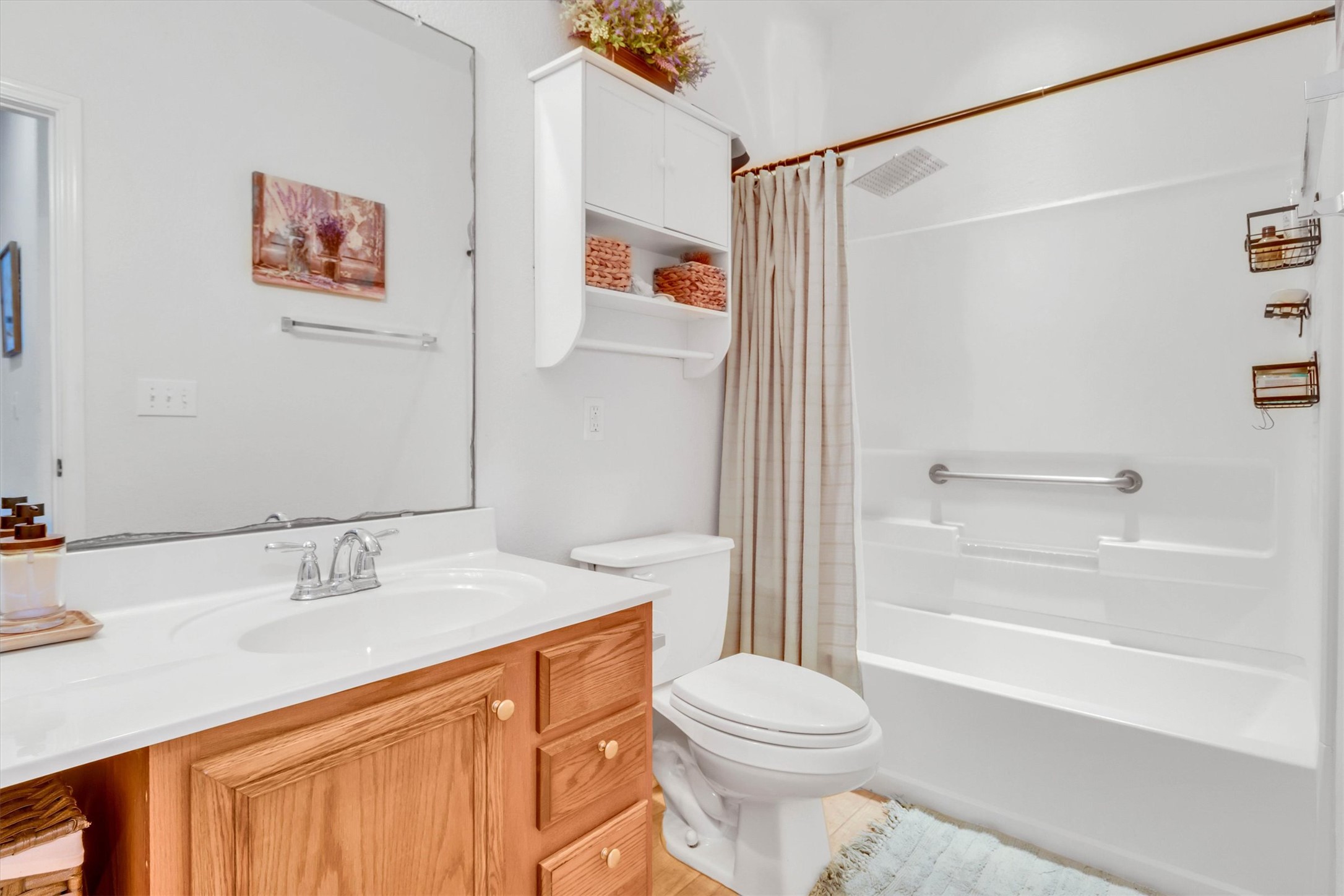 460 Waterleaf Boulevard Kyle, TX 78640 - Photo 21 of 30 A well-maintained bathroom with a classic wood vanity and a pristine tub-shower combination.