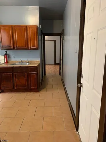 a view of kitchen with granite countertop cabinets and black appliances