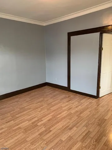 a view of empty room with wooden floor and closet