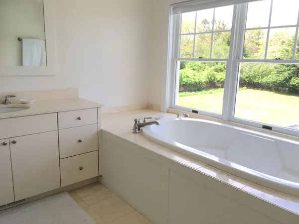 a large bed sitting in a bedroom next to a window