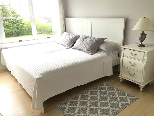 a large bed sitting in a bedroom next to a window