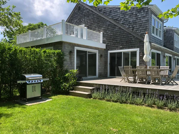 a view of a house with a yard fire pit and outdoor seating