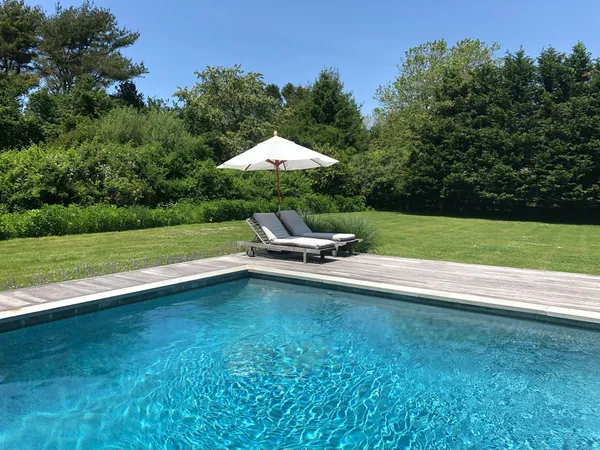 a swimming pool with outdoor seating and garden