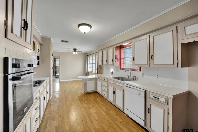 a large kitchen with a lot of counter space and wooden floor
