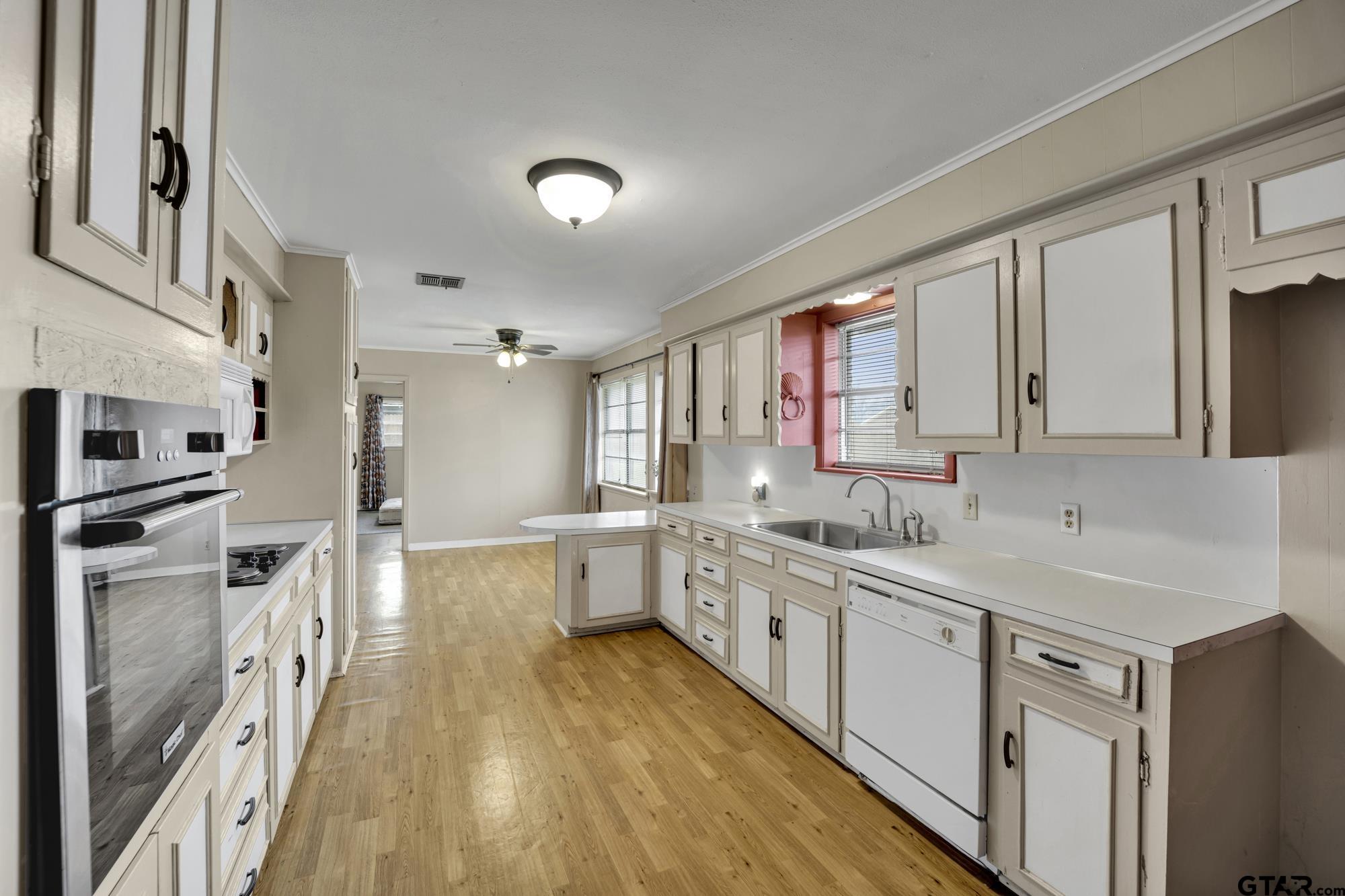 3204 West Tulsa Street Tyler, TX 75702 - Photo 11 of 24 a large kitchen with a lot of counter space and wooden floor