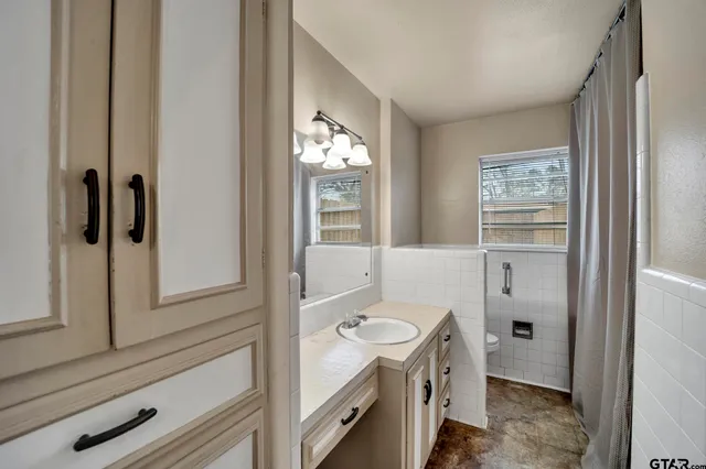 a bathroom with a granite countertop sink toilet and shower