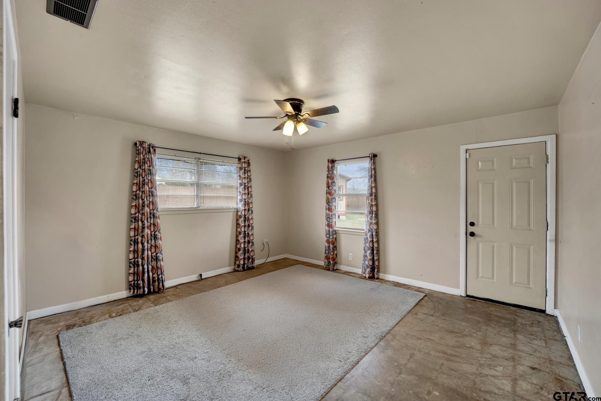 3204 West Tulsa Street Tyler, TX 75702 - Photo 20 of 24 an empty room with windows and fan