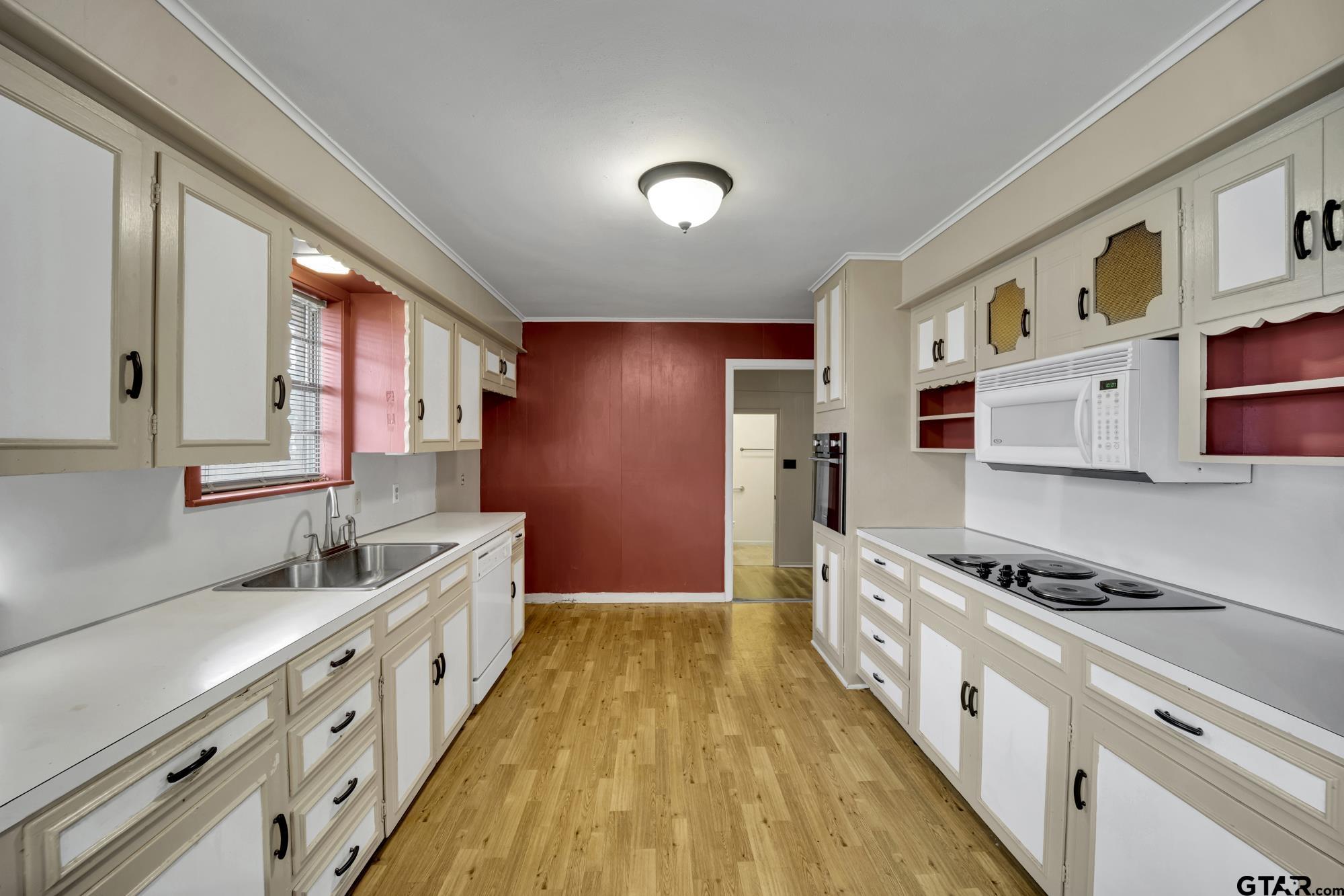 3204 West Tulsa Street Tyler, TX 75702 - Photo 10 of 24 a kitchen with granite countertop a sink a counter space cabinets and stainless steel appliances