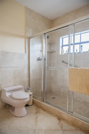 a bathroom with a toilet and a shower