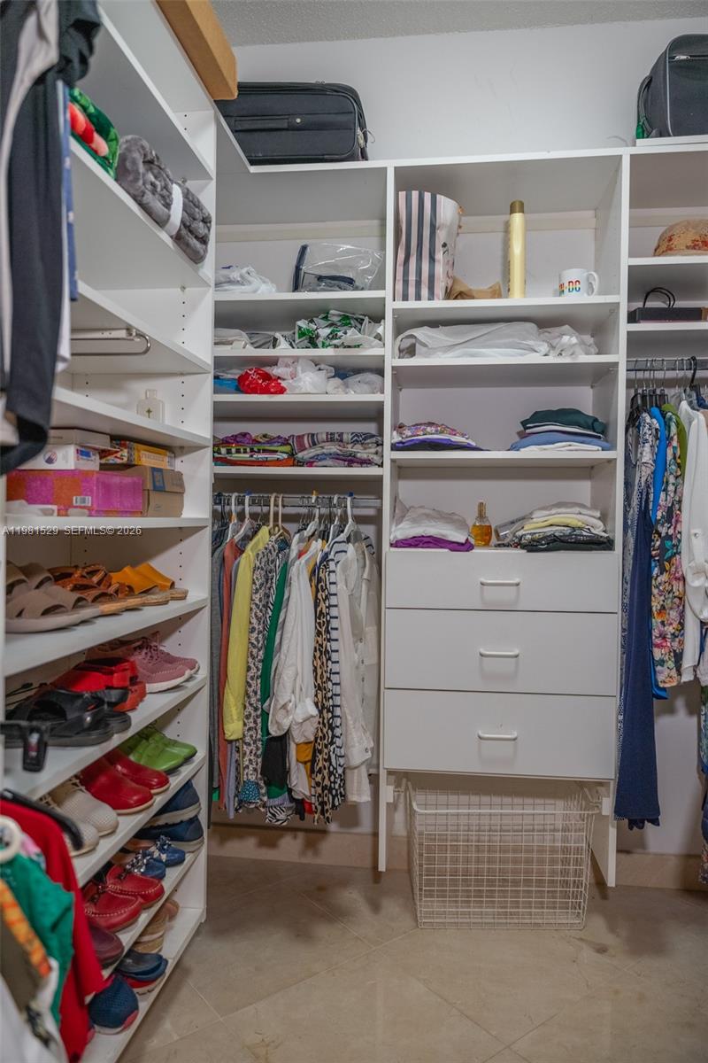 4655 Southwest 89th Avenue Miami, FL 33165 - Photo 15 of 38 a view of walk in closet with clothes and shoes