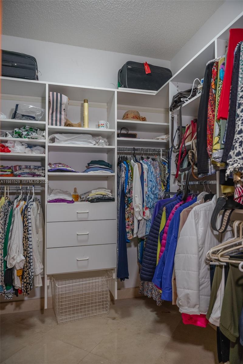 4655 Southwest 89th Avenue Miami, FL 33165 - Photo 16 of 38 a view of walk in closet with clothes and shoes