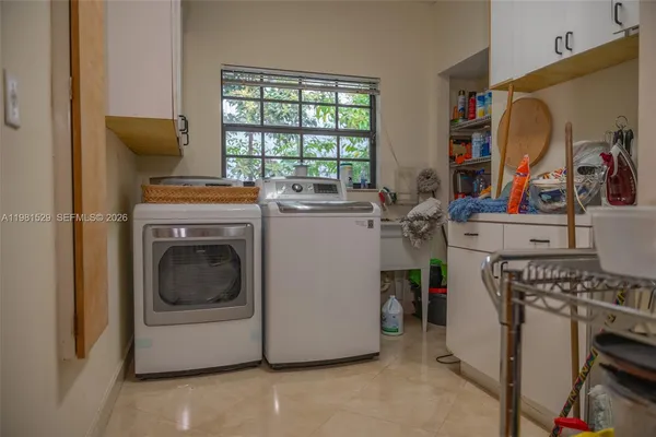 a utility room with dryer washer and a window