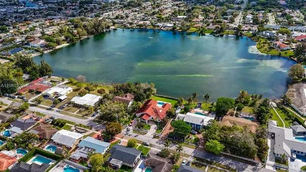 an aerial view of residential houses with outdoor space and lake view