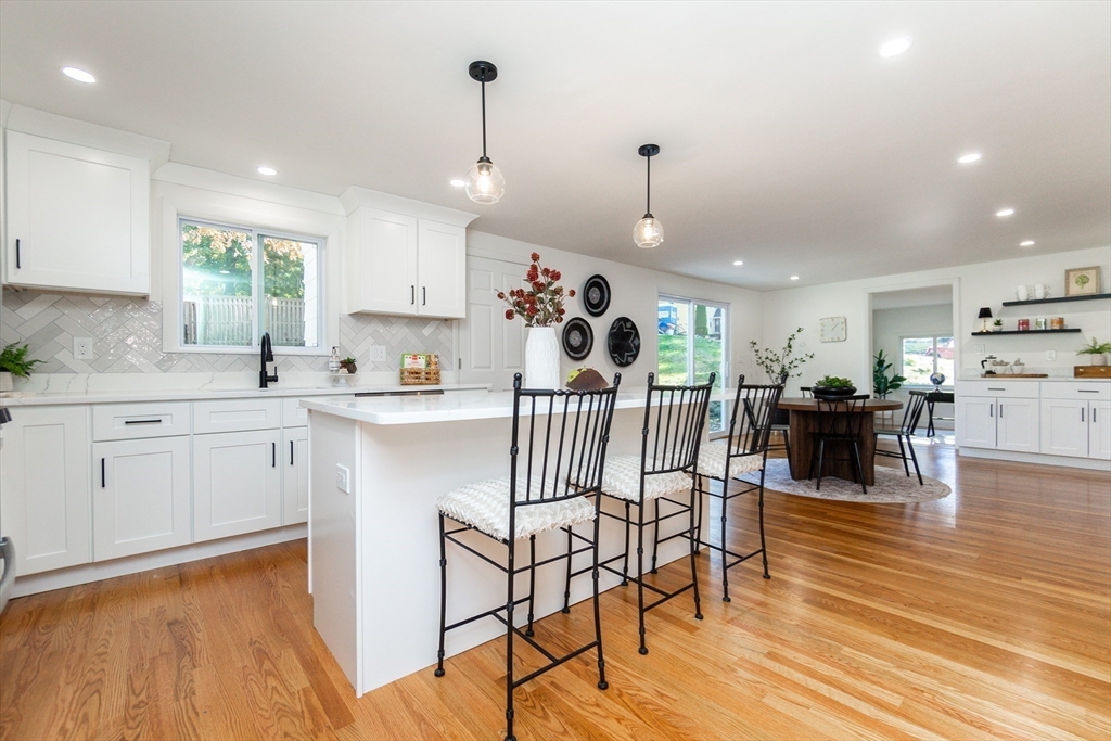72 Outlook Road Wakefield, MA 01880 - Photo 3 of 42 a kitchen with stainless steel appliances kitchen island granite countertop a table chairs and white cabinets