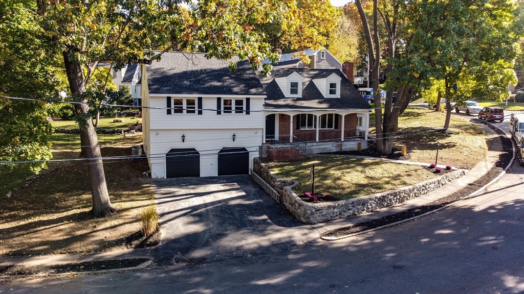 72 Outlook Road Wakefield, MA 01880 - Photo 37 of 42 a view of a white house with large trees and a small yard